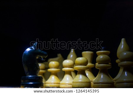 Black Horse stands opposite the white pawns on a chessboard