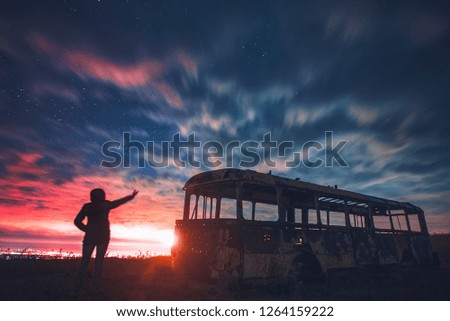 Landscape with blue sky and yellow light. Girl looking at the night city.