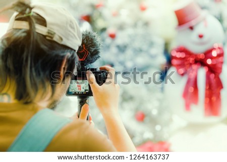 Photographer man take photo of decorated Christmas tree and a snowman.