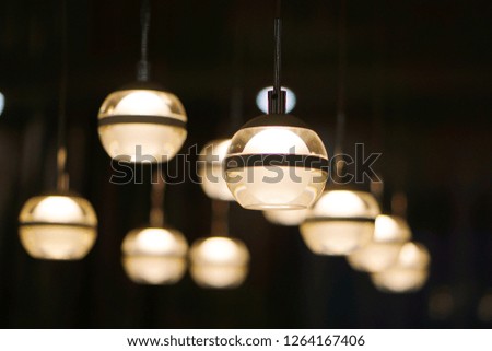 many round glowing lamps hanging on a dark background