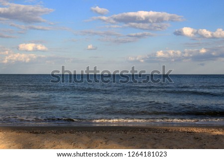 A photo of sand gradually melding into the Azov sea with the focus of the image on the beach itself.