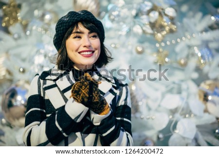 Picture of happy woman on walk next to decorated white spruce