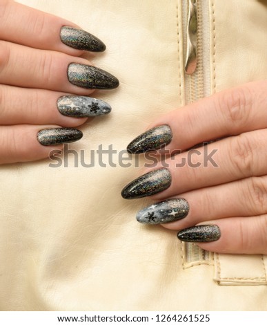 Nails covered with gel lacquer black with Christmas design and stretching loose sequins silver holographic color