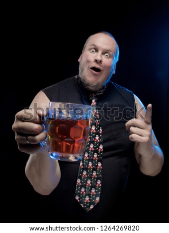 Man in cap with a glass of beer on a black background, in anticipation of Christmas and New Year
