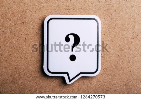 Question Mark speech bubble sign isolated on brown paper background with shadow.