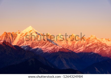 Panoramic view during sunset over snow cladded Panchchuli peaks falls in great Himalayan mountain range from Khalia top trekk trail at small hamlet Munsiyari, Kumaon region, Uttarakhand, India. Royalty-Free Stock Photo #1264324984