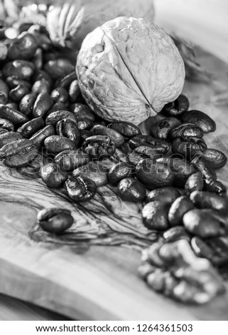 Roasted coffee beans on the desk made from olive tree with contrast picture on the surface in morning sun rays and with shadows 