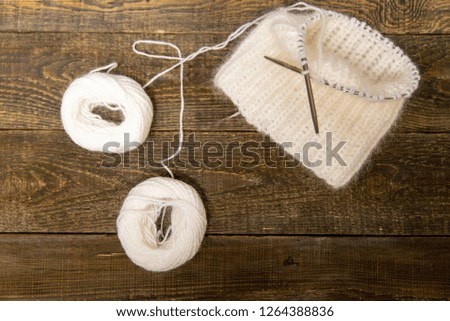 light knitting lies on a dark wooden background