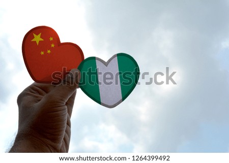 Hand holds a heart Shape China and Nigeria flag, love between two countries