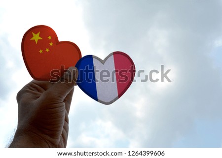 Hand holds a heart Shape China and France flag, love between two countries
