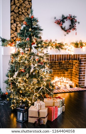 new year's interior with a Christmas tree and gifts in hand on the background of fireplace lights