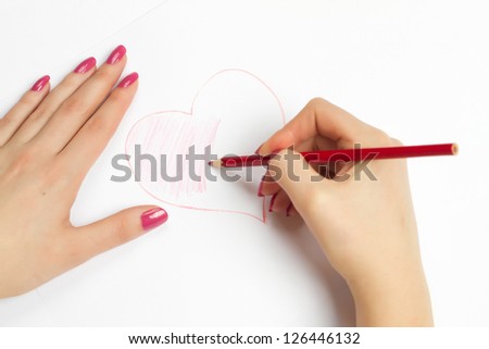 hands painting a heart with a red pencil