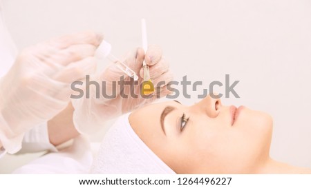 Young woman cleaning face skin in salon. Retinol peel with brush. Acid organic peeling. Royalty-Free Stock Photo #1264496227