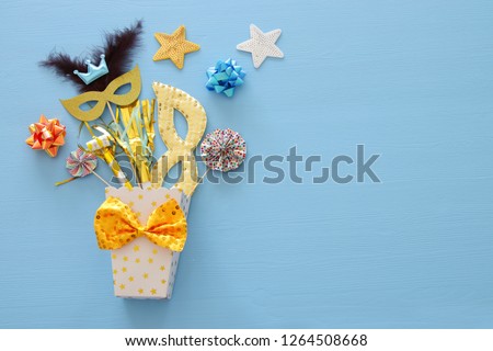 carnival party celebration concept with mask and colorful party accessories over blue wooden background. Top view