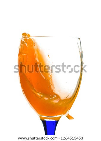 Beautiful and diverse subject. Beautiful and stylish glass and glass with orange juice poured and splashed on a white insulating background.