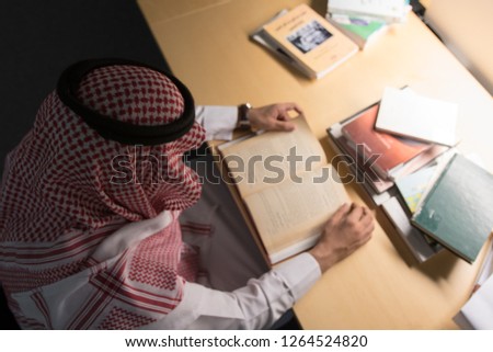 Saudi Arabian Man Reading a Book in The Library