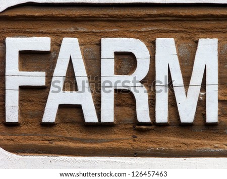 Old wooden farm sign carved out of barn wood