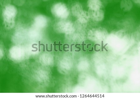 Vibrant ufo green tone of blurred trees with lighting bokeh. Freshly greenery image for background. Light and shade in modern green environmental concept. 