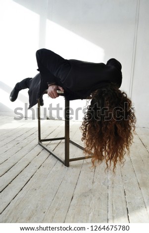 photo guy with long curly hair in black clothes lying on the table white background