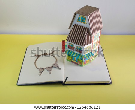 Photo of model cardboard house with keys isolated on background. Photo for advertising sales, rentals, realtor and construction services. House, home In, interior. Architectural and business.