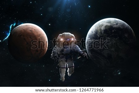 Earth and Mars. Solar system. Astronaut on background of the planets. Science fiction art. Image in 5K for desktop wallpaper. Elements of the image were furnished by NASA