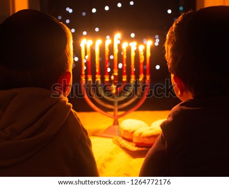 A child looking at Hanukkah candles. It is a Jewish custom to light candles on the 8 days of Hanuka celebrating the miraculous victory over the ancient Greeks during the Second Temple period.