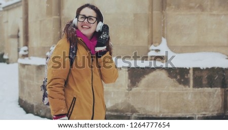Attractive young girl Going the city and listening to music with her wireless earphones