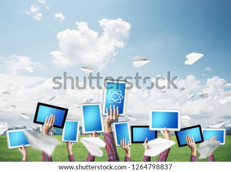 Set of tablets in female hands against nature background and paper planes in air