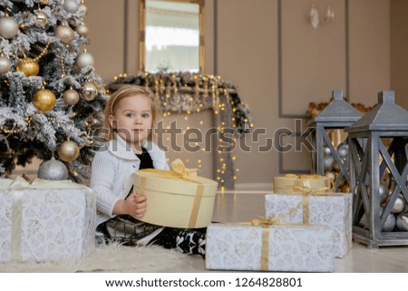smiling cute little girl opening a Christmas gift, the background Christmas .