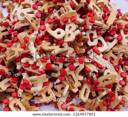 A mountain of handmade wooden letters with red wheels as a base. Horizontal view