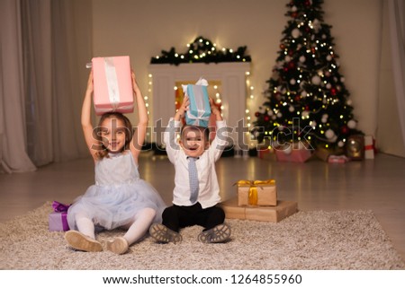 a boy with a girl open Christmas presents new year holiday Garland lights