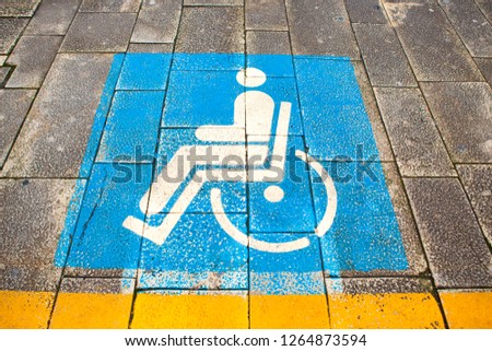 Marked sign for people with special needs and disabled people on the street in the parking. Sicily, Messina, Italy