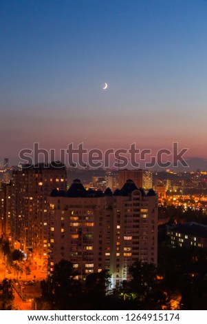 Evening in Kiev, a top view city, the night streets and the new moon in the sky.