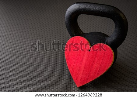 Black kettlebell on a black gym floor with large red heart to celebrate Valentine’s Day fitness
 Royalty-Free Stock Photo #1264969228