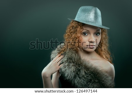 Beauty young woman in hat and fur studio shot