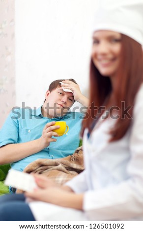 Woman doctor examining the patient in home. Focus on man