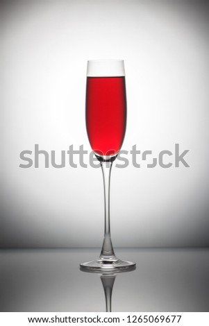Red wine in а glass on grey background.