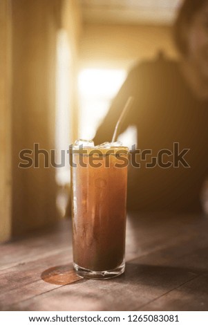 Ice Americano coffee with flare morning golden light over vintage style.