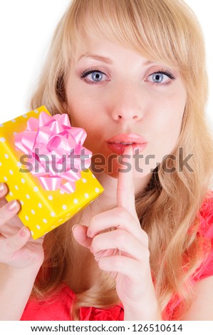 Happy woman looking giving hush sign holding a gift. present for a surprise.  Caucasian female model showing a secret gift box