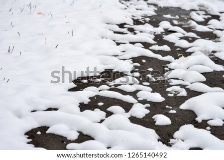 Winter background. The snow is melting and looking through the ground. Royalty-Free Stock Photo #1265140492