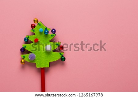 Felt Christmas tree toy on red wooden stick with small bells baubles. Small jingles on decorative green tree, clinking