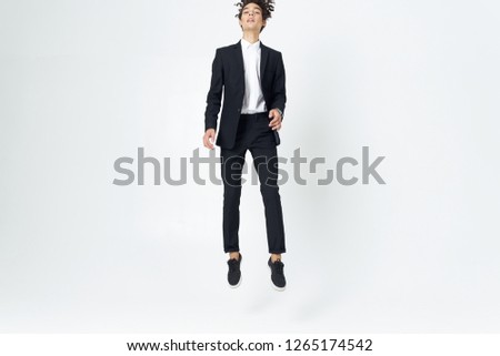 Curly man in a dark suit bounces up                   