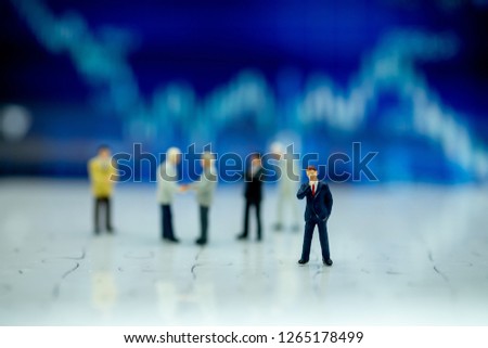 Miniature people: Businessman standing on white floor and front of dashboard, display graphs, profit margins of background. picture use for business concept.