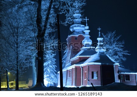 Beautiful illuminated wooden church photography  in the night  winter full of snow Tylicz Poland Royalty-Free Stock Photo #1265189143