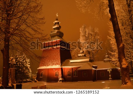 Beautiful illuminated wooden church photography  in the night  winter full of snow Tylicz Poland Royalty-Free Stock Photo #1265189152