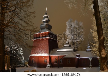 Beautiful illuminated wooden church photography  in the night  winter full of snow Tylicz Poland Royalty-Free Stock Photo #1265189176