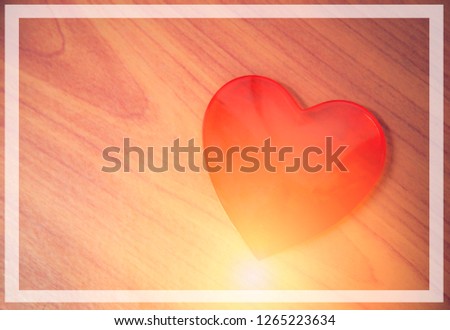 Red heart shaped with light on wooden background   