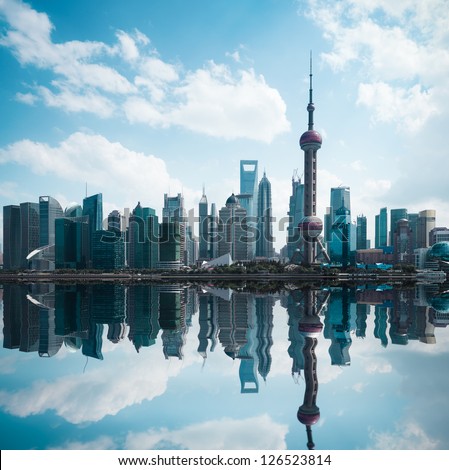 shanghai skyline against a blue sky with reflection