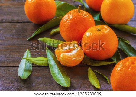 tangerines on wooden background close-up. background with a bunch of tangerines and leaves.