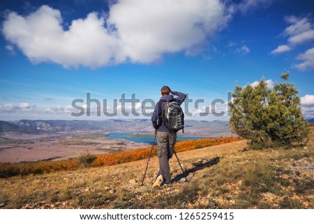 Traveler in the mountains. Photographer on top of mountain. Job scene